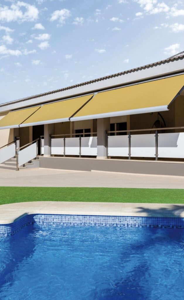 Toldos retráctiles amarillos en terraza con piscina